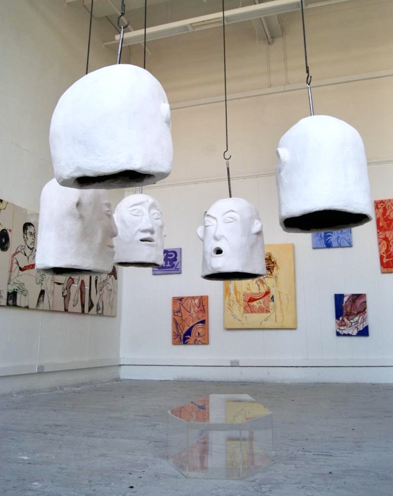 5 plaster heads, filled with sounds, surrounding a plexiglass casket