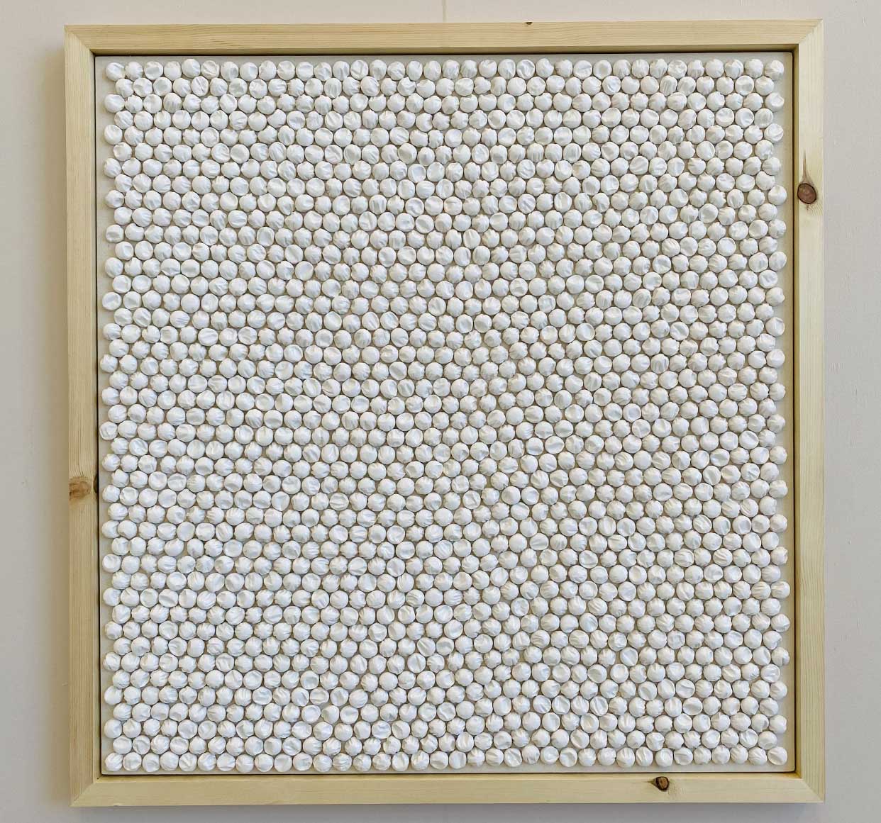 Frontal view of wall piece. Ceramic bubbles on canvas arranged on a beehive pattern