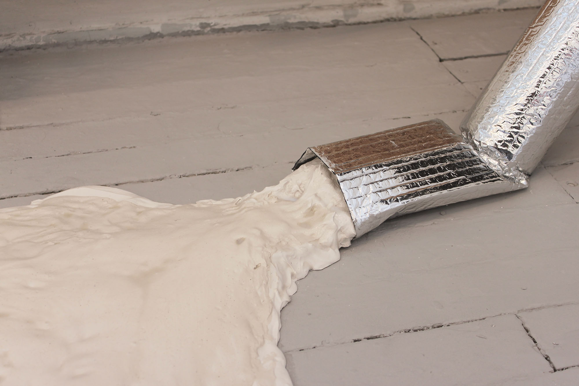 Close-up of a Polyfilla puddle spilling from a foil insulated pipe