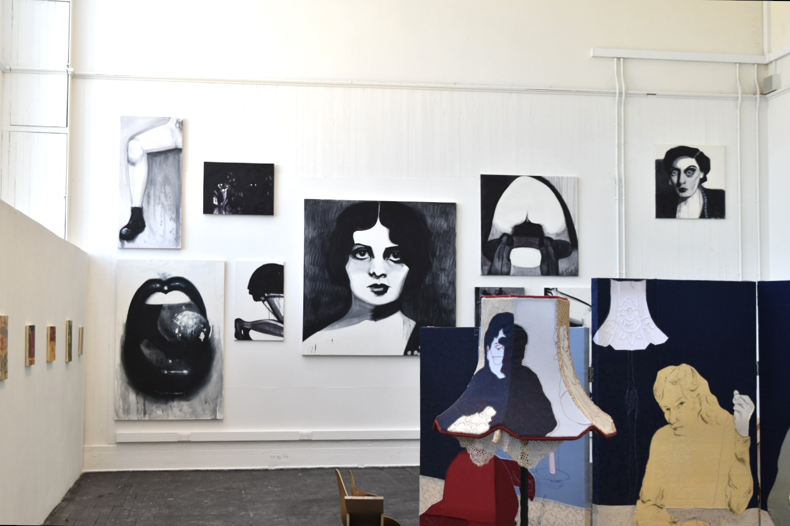 collection of installed black and white canvases with a fabric screen in front of mine by another artist