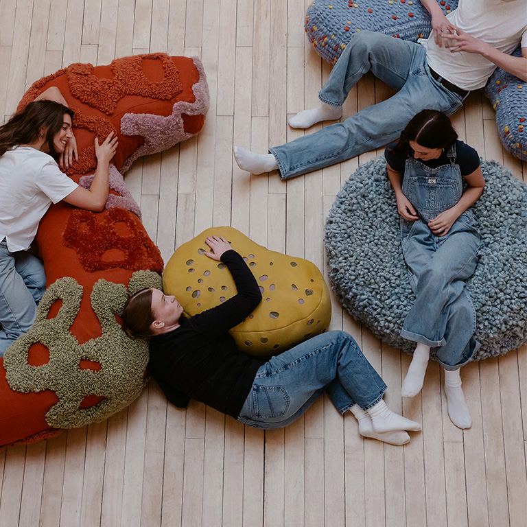 People laying and sitting on installation shapes