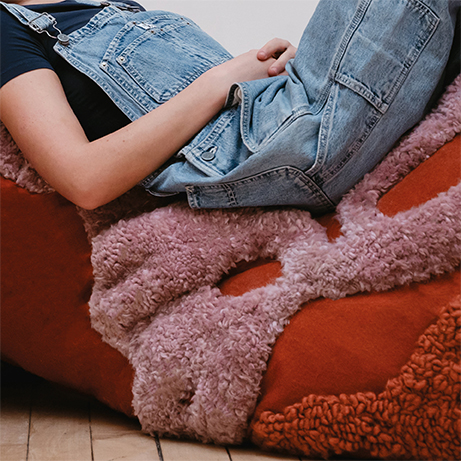 Person laying across curve of cushion shape