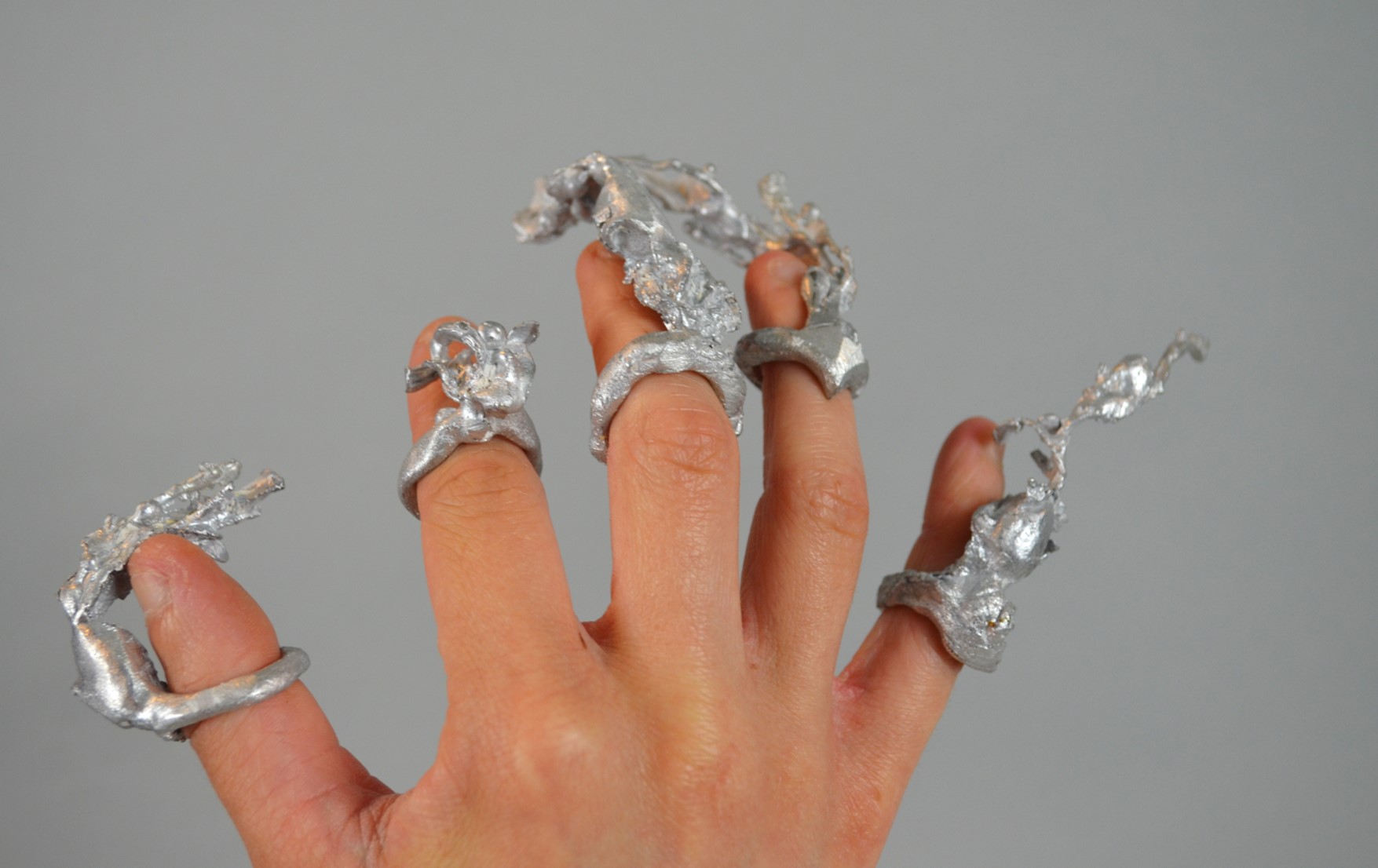 Alluminium casts of bladderwrack seaweed on the end of fingers.