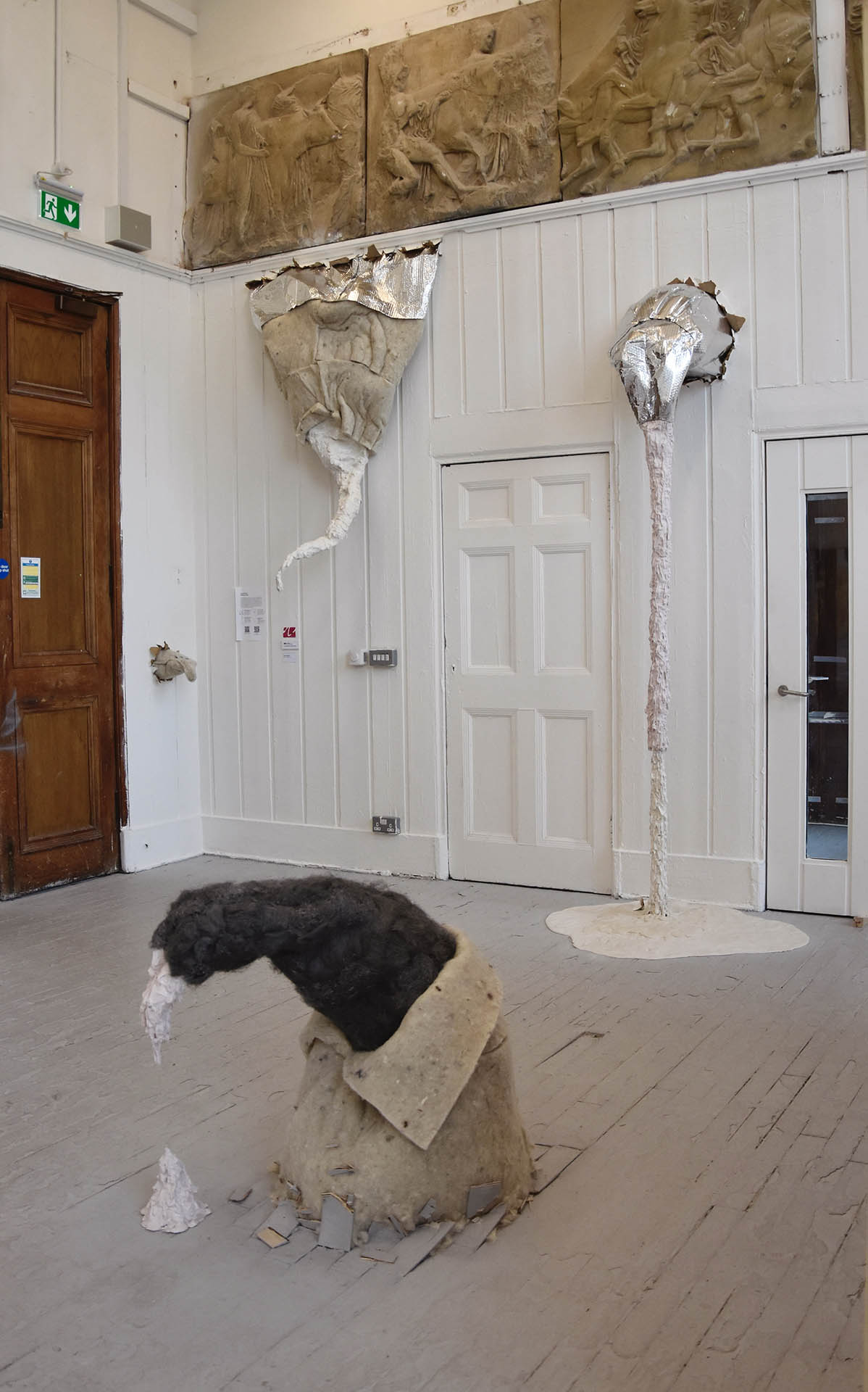 Sculptures made of insulation, silicone, Polyfilla, and steel wool burst from the walls and floors
