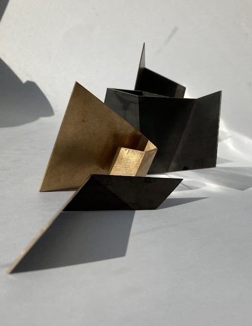 Bold gold and black angular metal sculpture with strong geometric lines