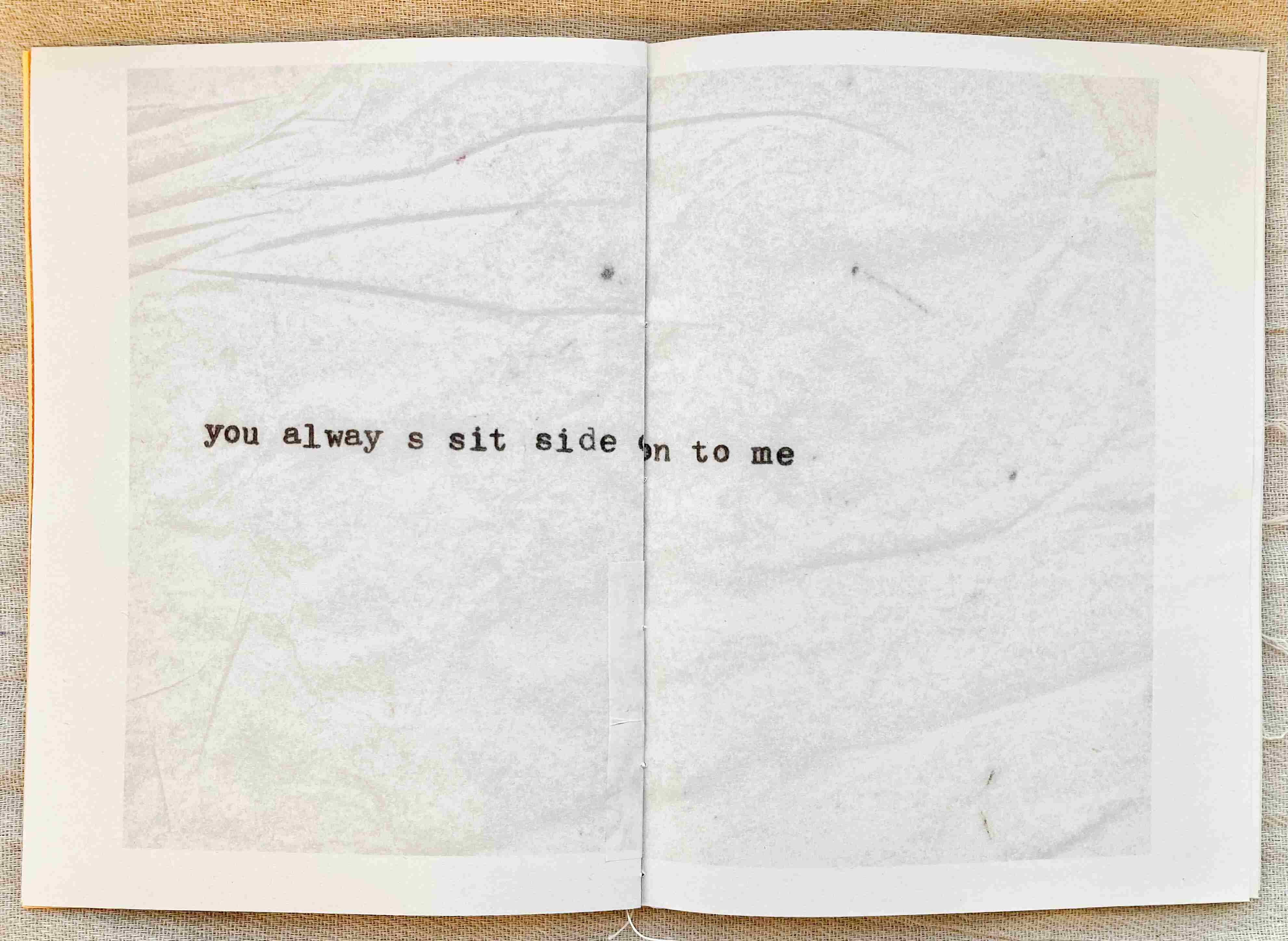Open page of a book which reads "you always sit side on to me"