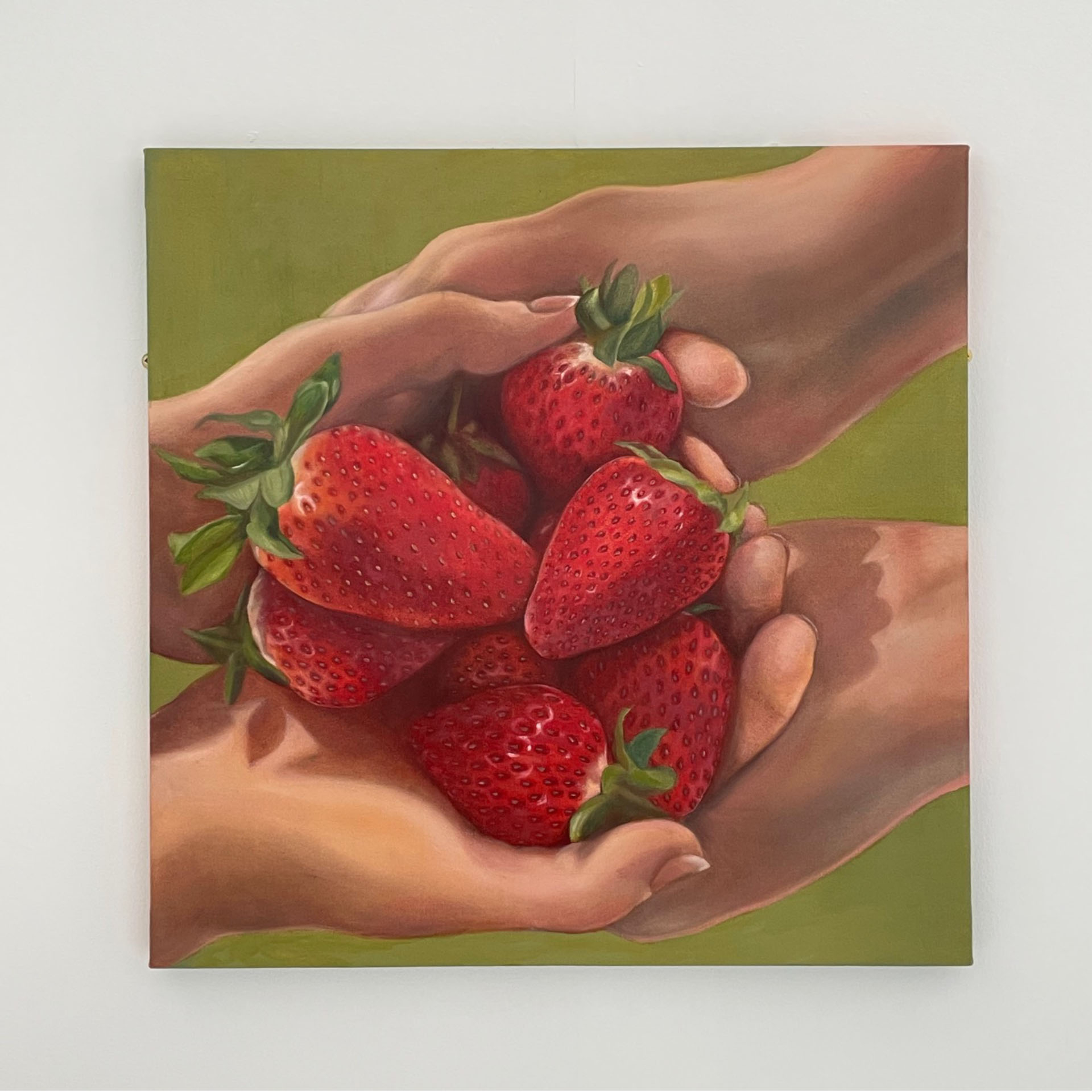 A painting of bright red strawberries being held by two people. 
