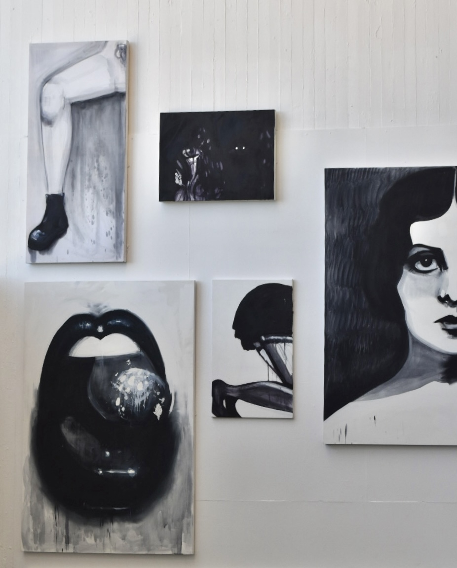 close up wall collage of black and white paintings, mouth, legs, half of a face 