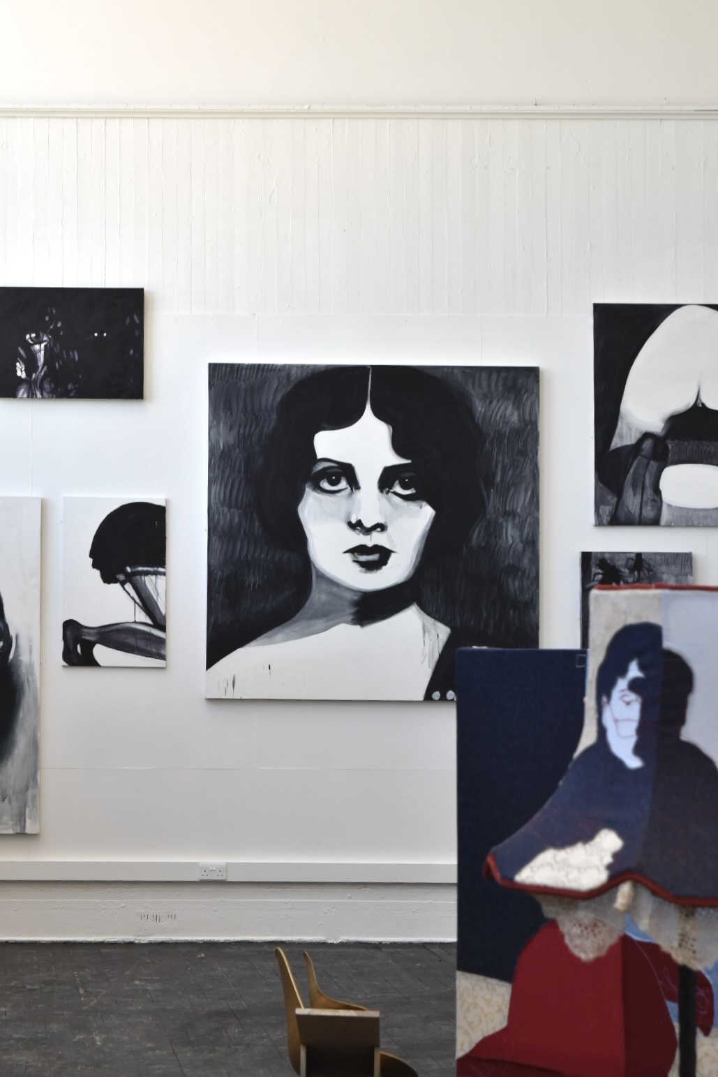 collection of monochrome canvases on the wall obstructed by a fabric screen by another artist
