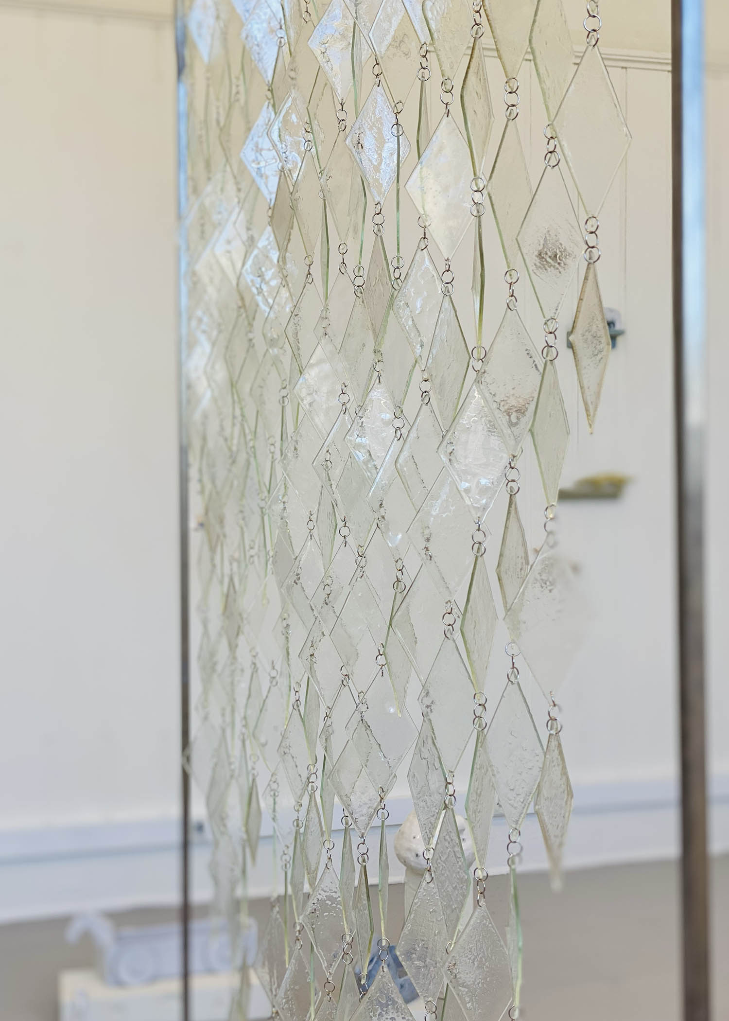 Closeup of curtain made of interlaced diamond shaped glass pieces