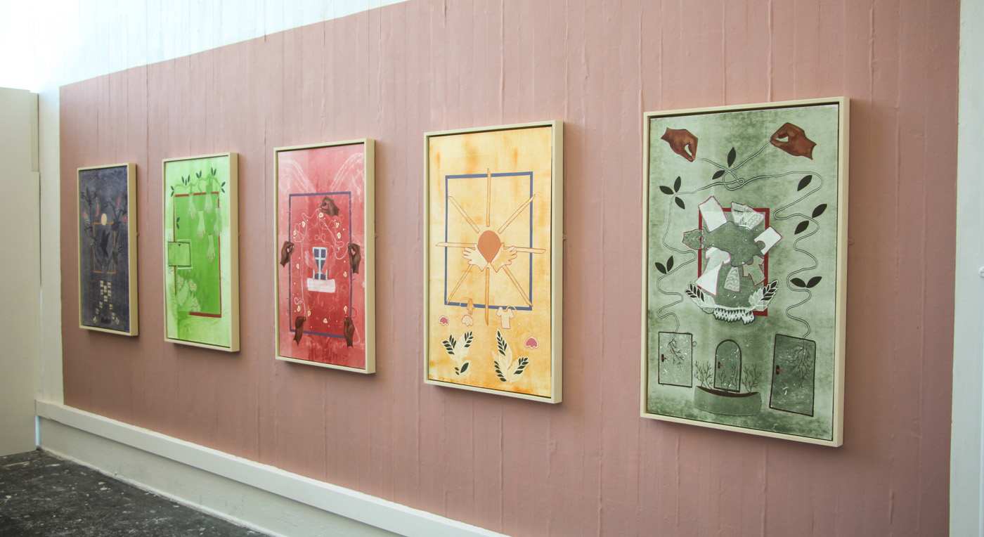 Five mono-prints installed on a pink wall 