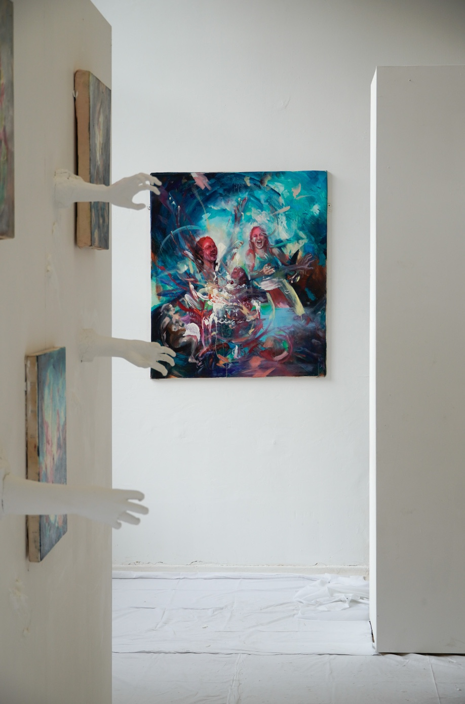 White hands reaching out and a blue painting in the background