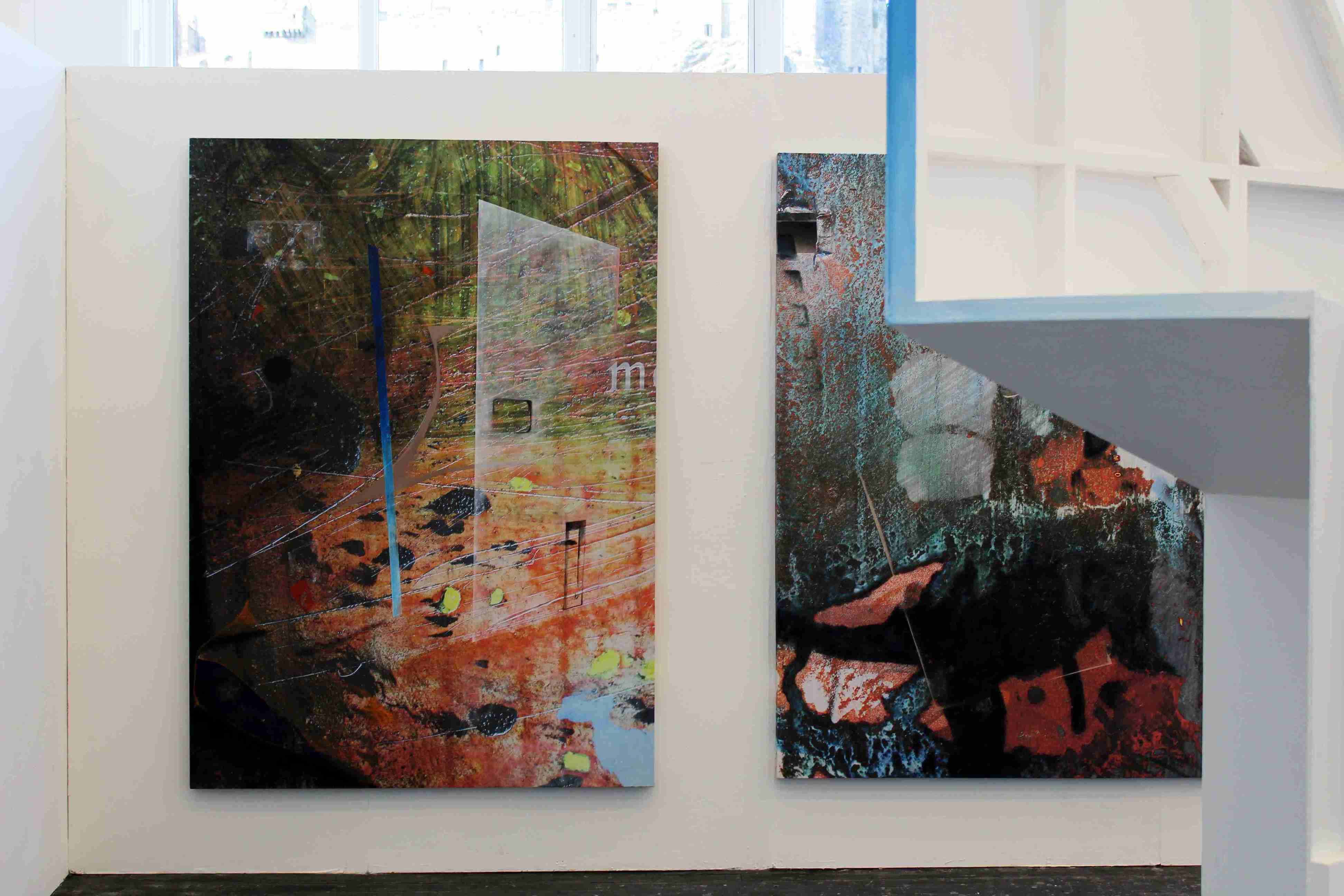 Two large abstract paintings, intersected by a white angular wall