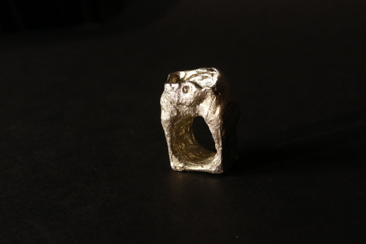 Pewter ring of a woman's lower torso.