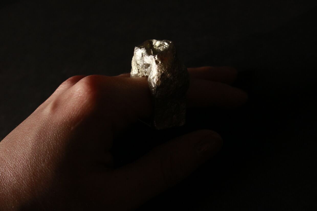 Pewter ring of a woman's lower torso, being worn.
