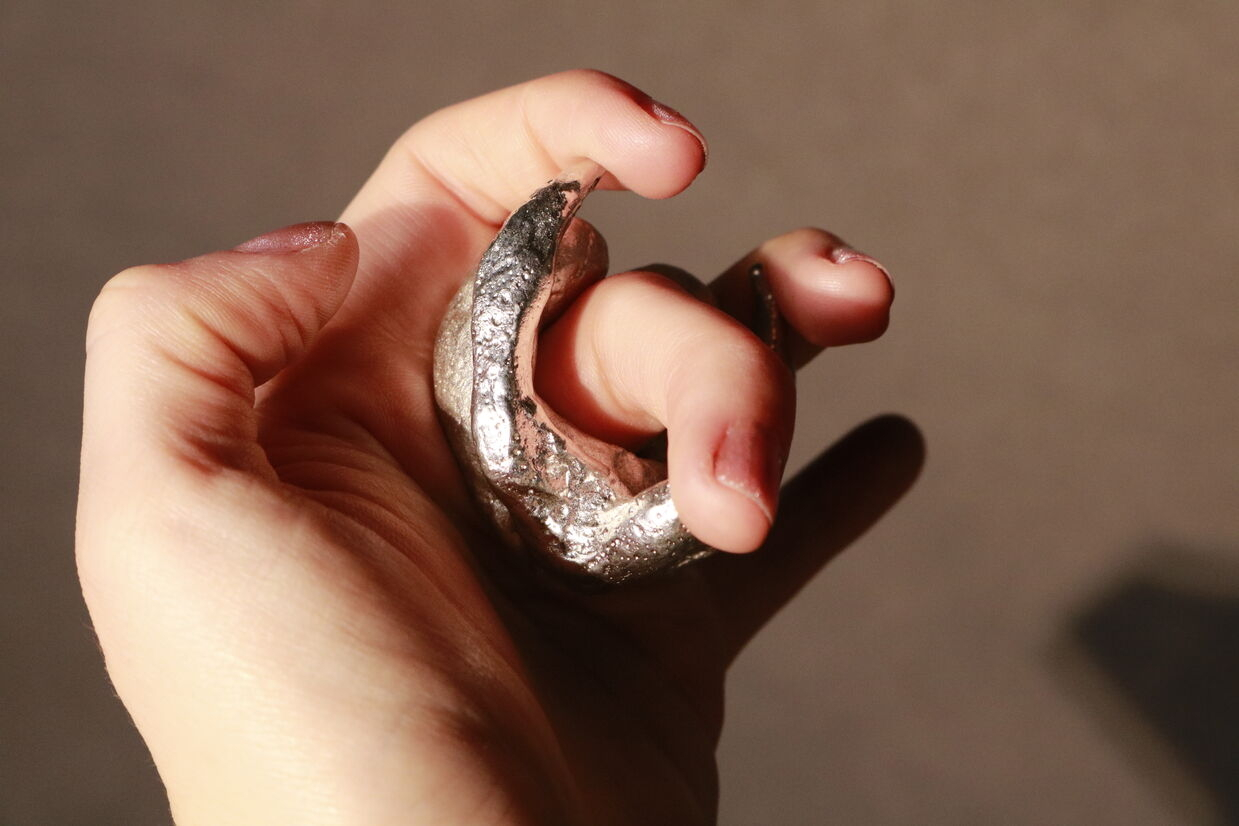 Pewter cast ring of a clitoris shape being worn.
