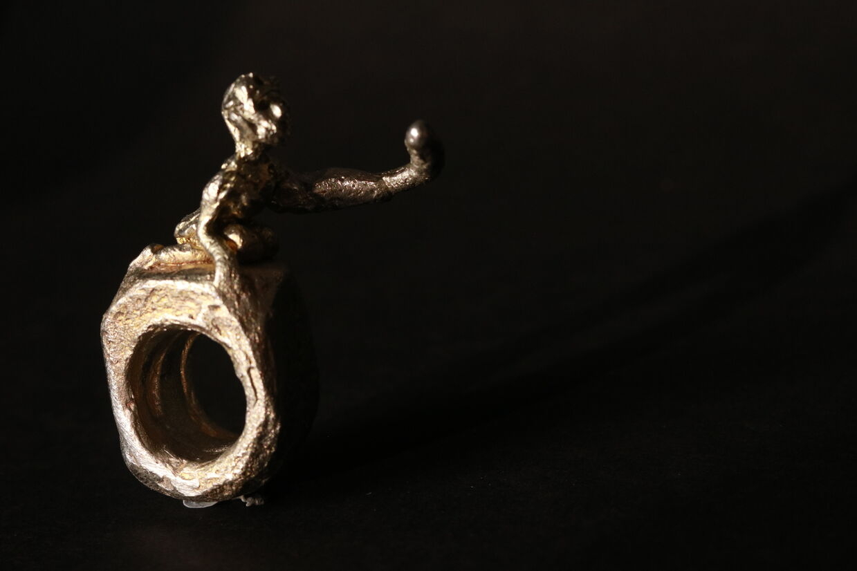 Pewter ring of a woman reaching out. 