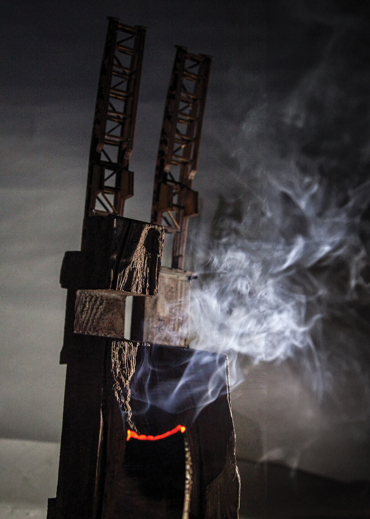 Edge Structure model showing smoke lightly burning a timber structure against a dark background.