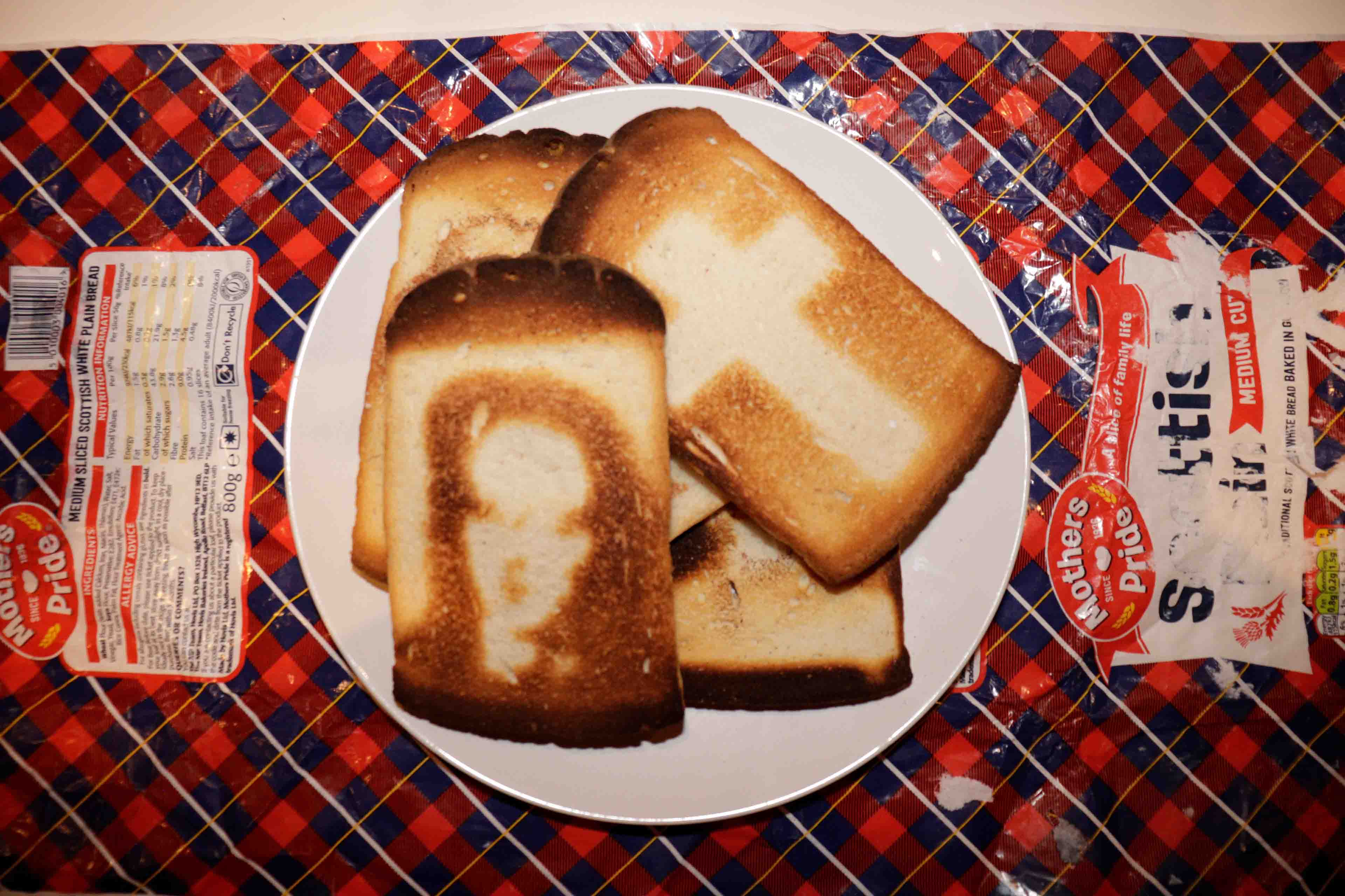 Toast with burnt on icons, arranged on a plate over tartan paper