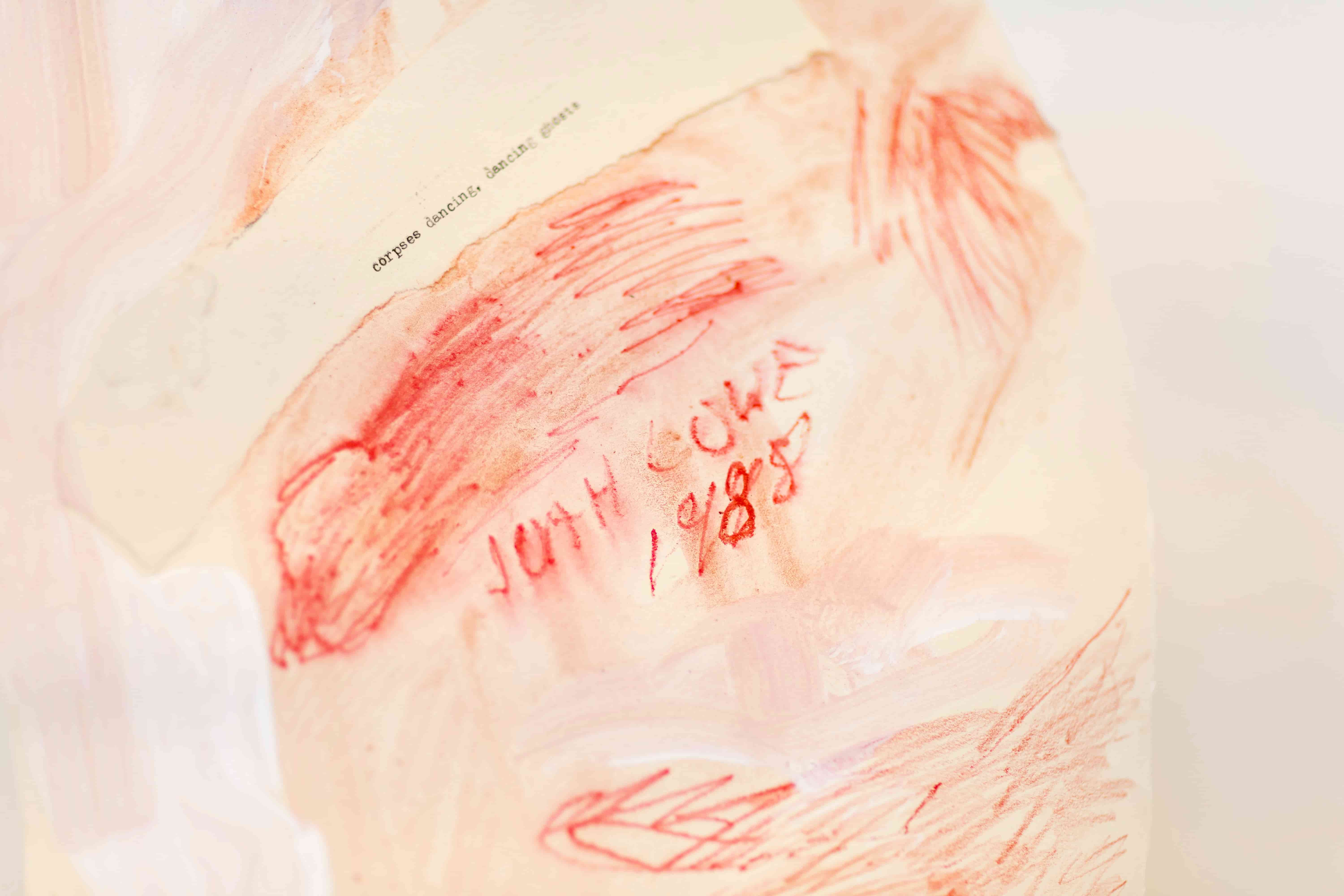 Close up of a white and red artwork on paper. Text on the work reads 'Corpses Dancing, Dancing Ghosts' and 'Joah Lowe, 1988'
