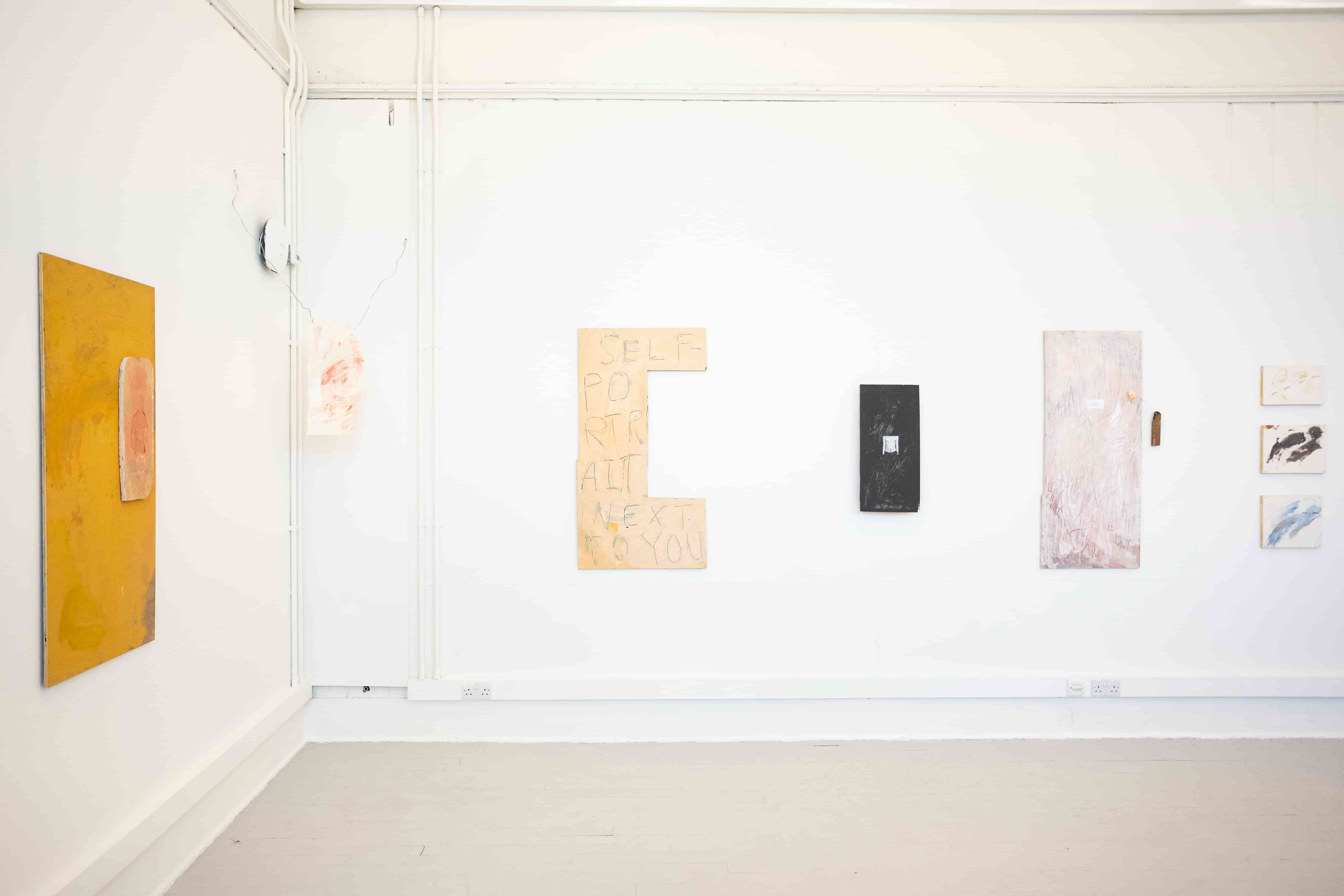 Image of a series of colourful artworks installed in a white, cornered space