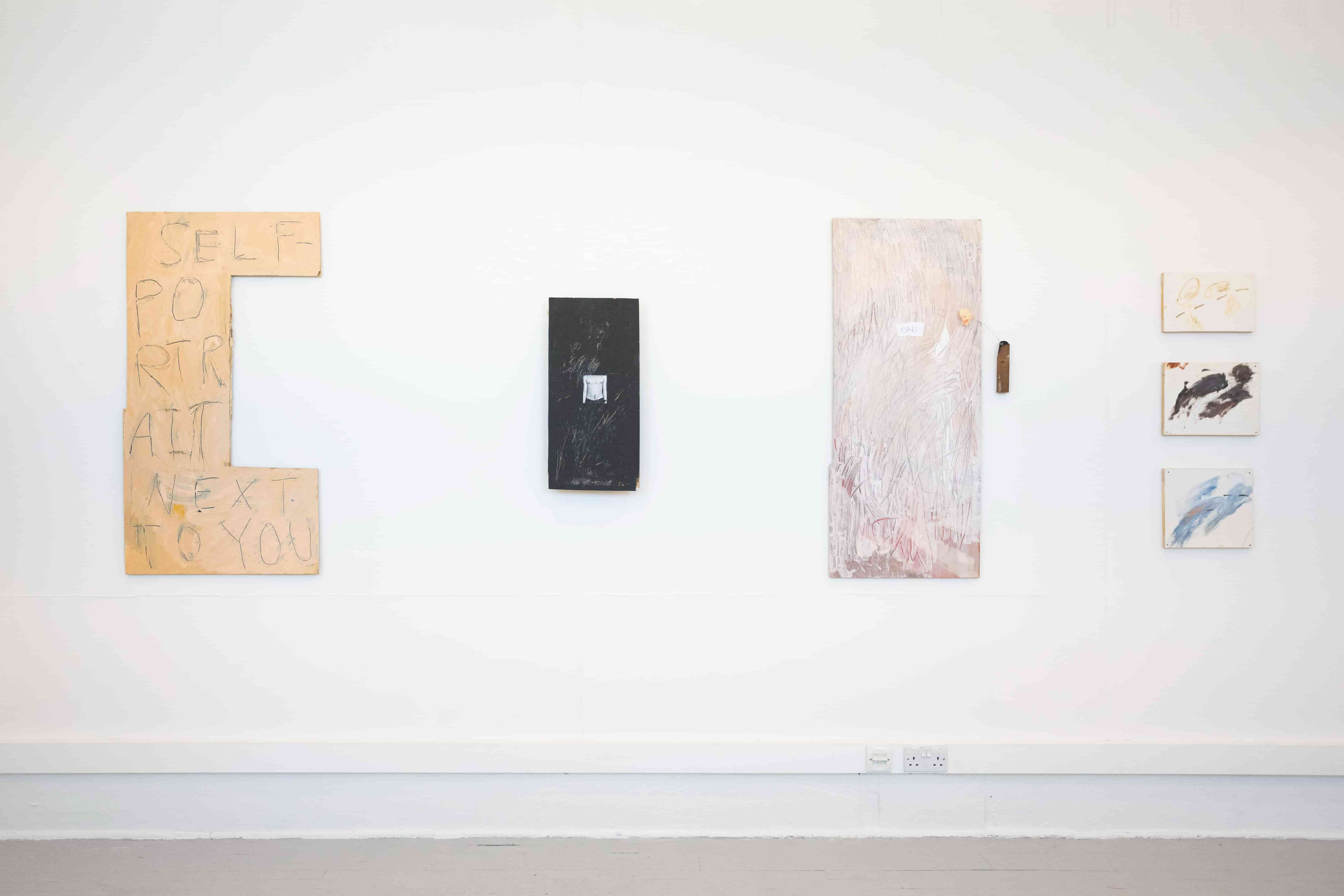 Image of a series of colourful artworks against a white wall