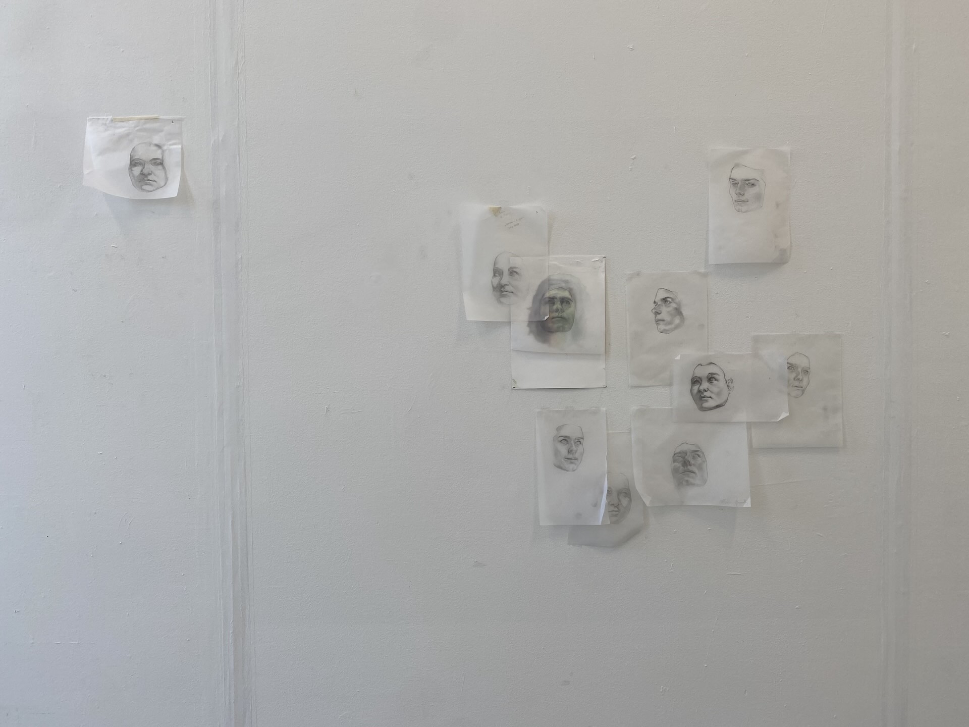 Arrangement of faces drawn on pieces of tracing paper