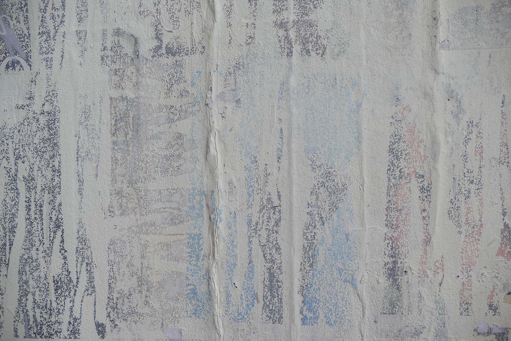 a detail of a grainy solvent transfer on the wall, resembling torn down posters 