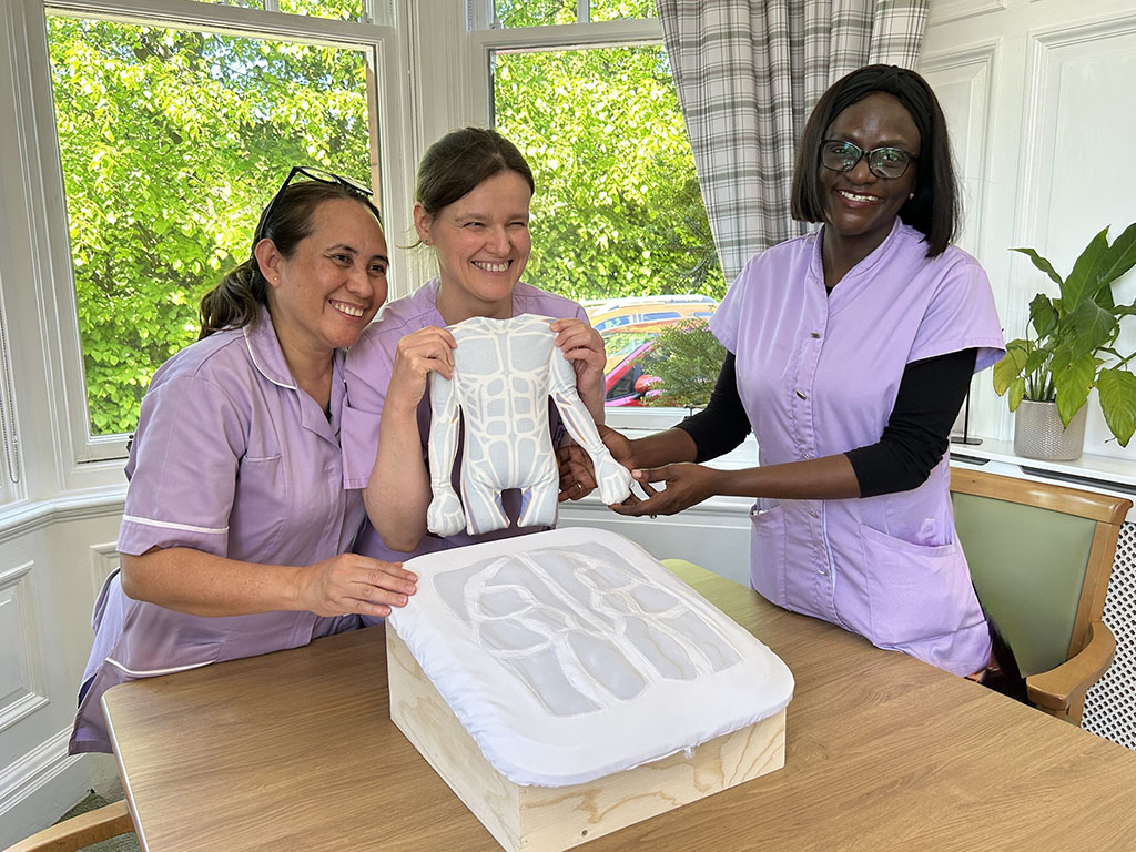 3 Carers holding the anatomical model 