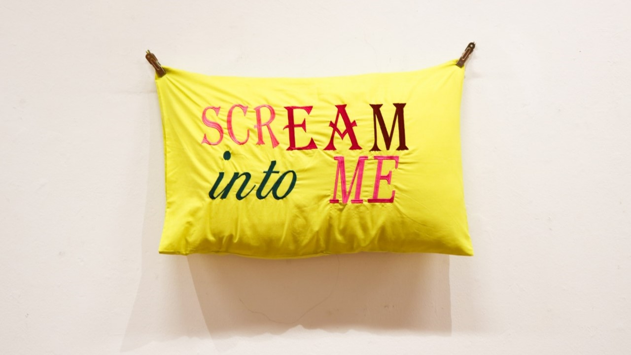 Chartreuse green pillow case with text written on it 'SCREAM into ME'