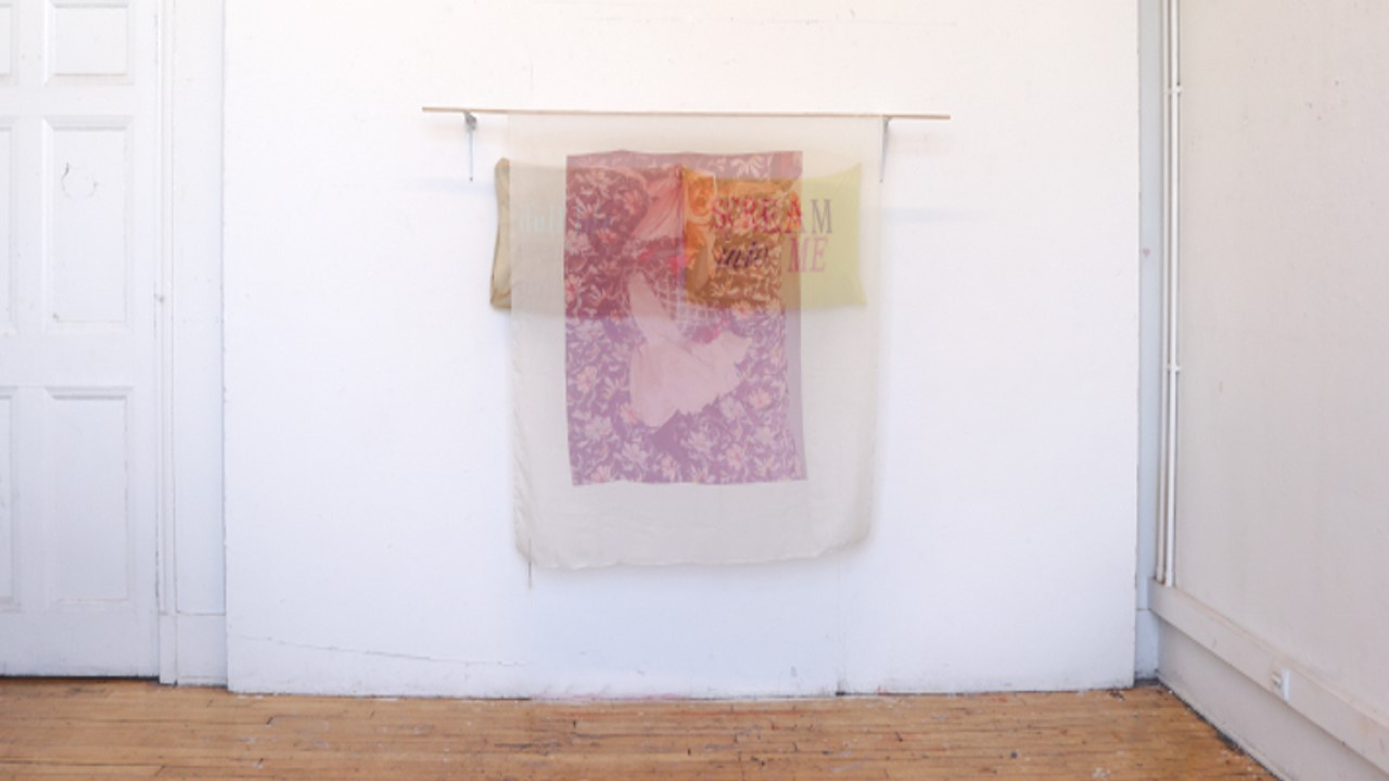 Pillow cases with fabric hung over it on the wall 