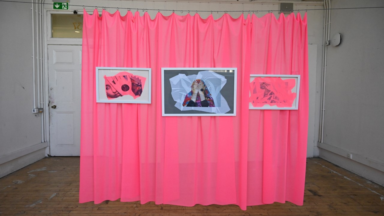 3 frames hanging in front of a hot pink curtain backdrop
