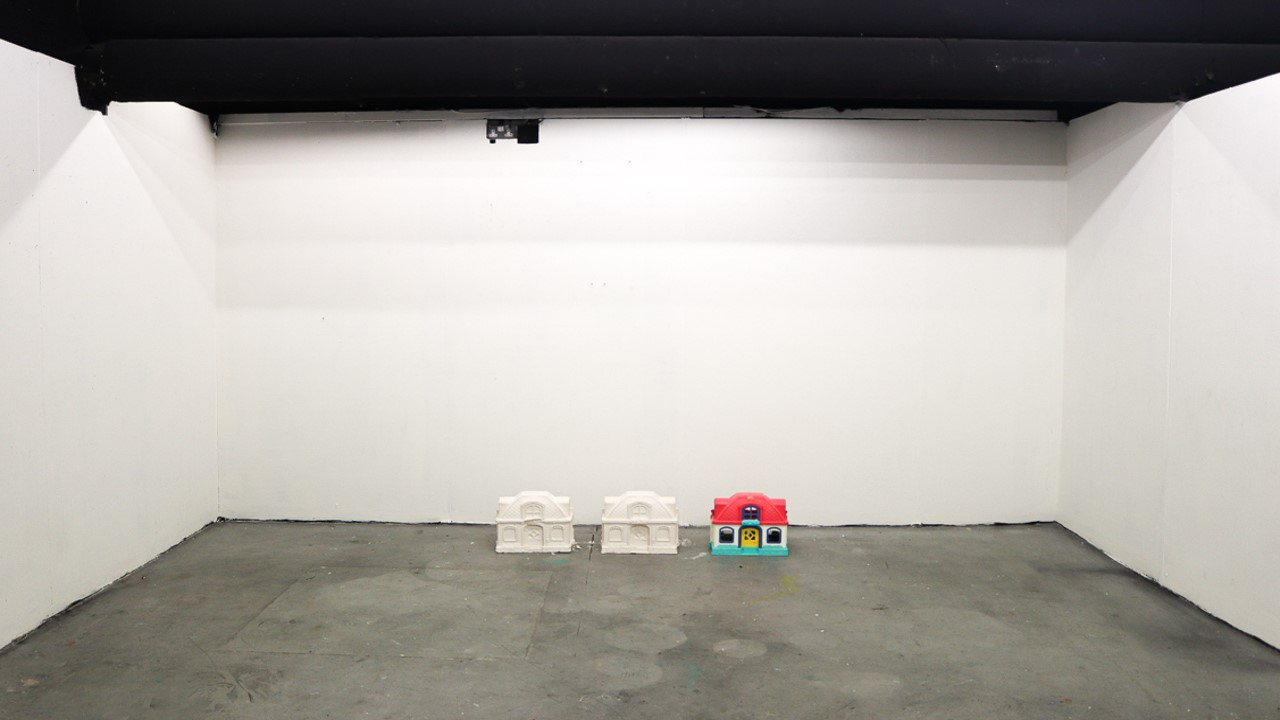 2 white doll house and one colourful dollhouse laid out on the floor