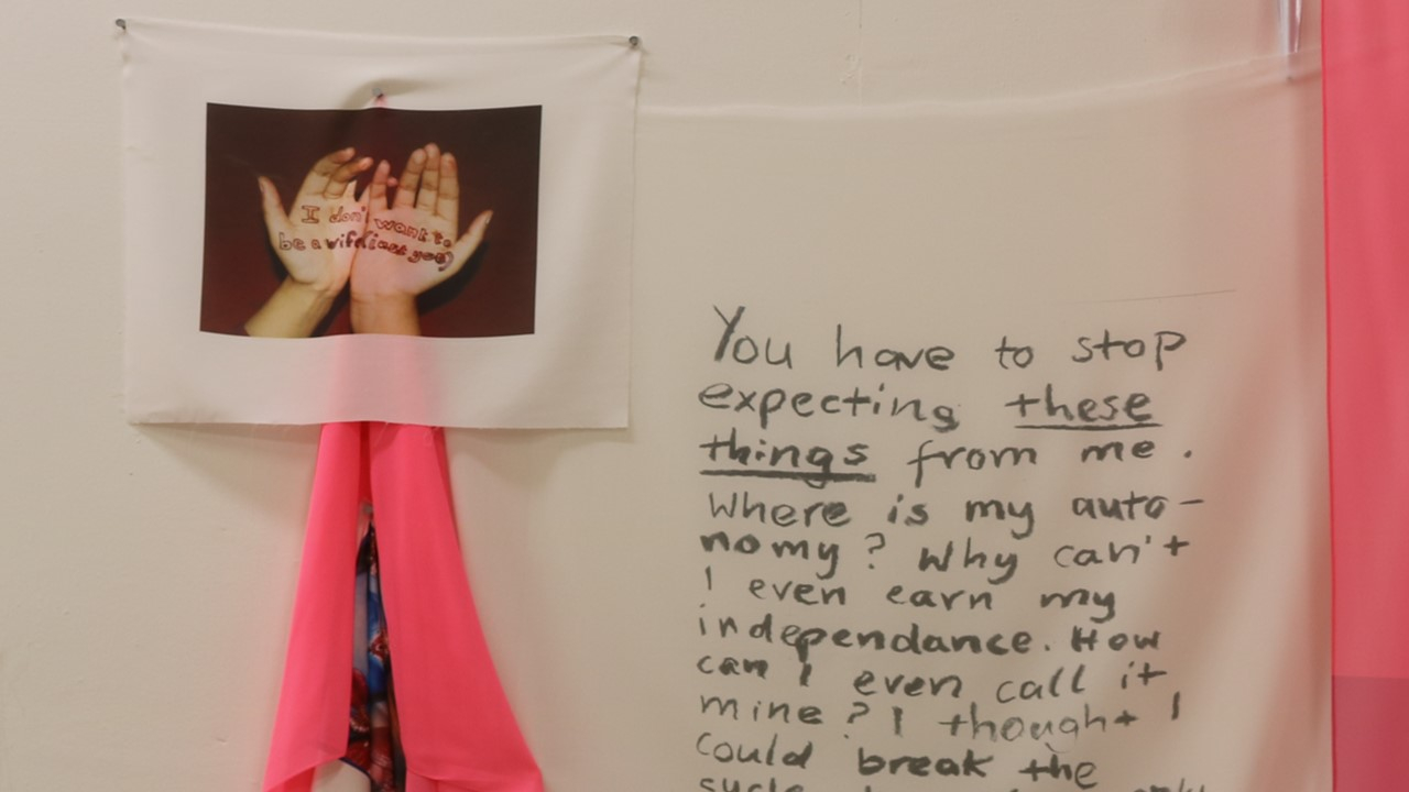 Close up of the text printed onto white fabric and a picture of hands with text on them