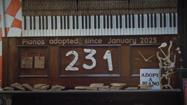 Sign that says 231 pianos adopted since January 2023