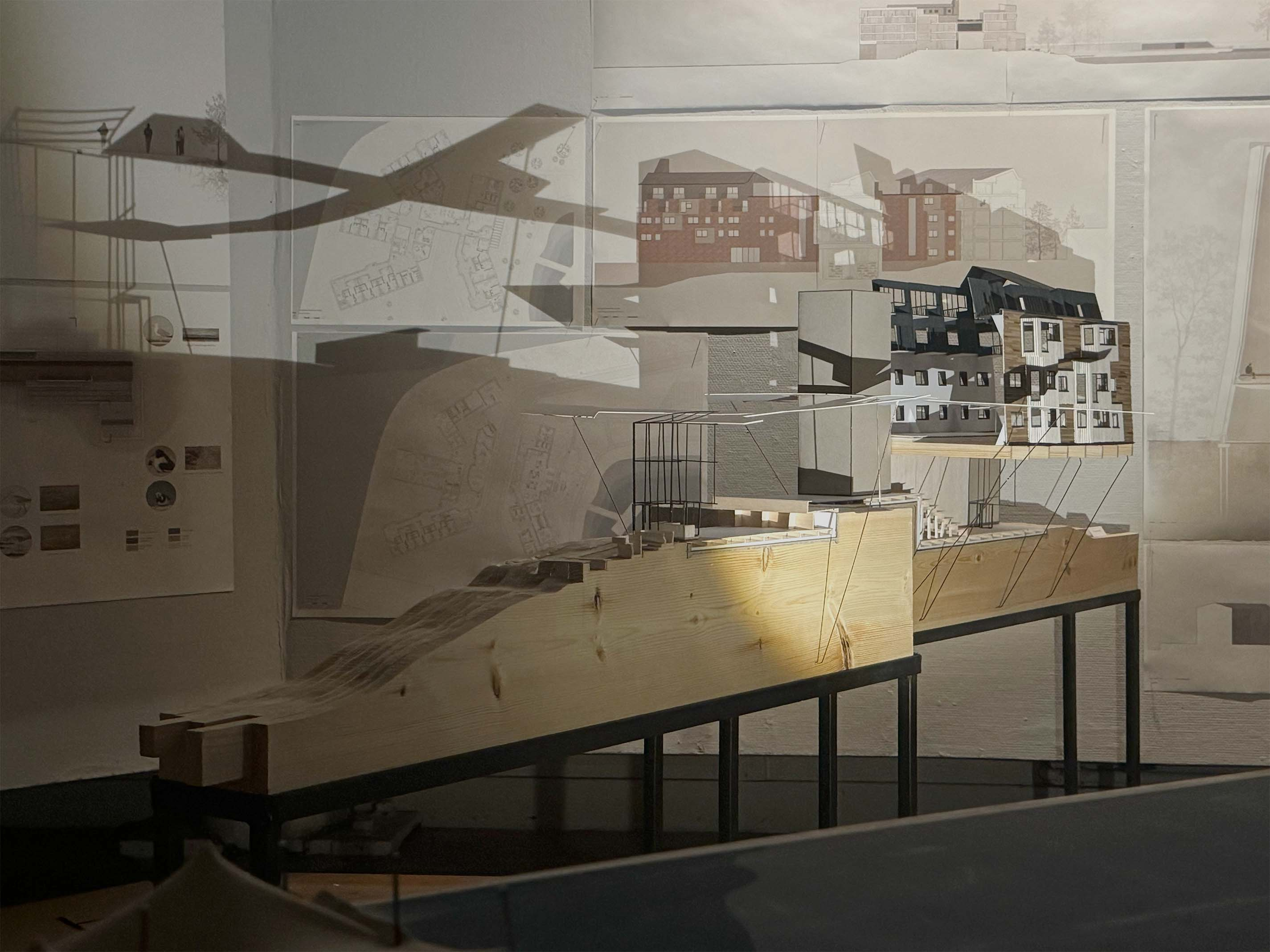 View of 1:50 model in front of exhibition installation with drawings.
